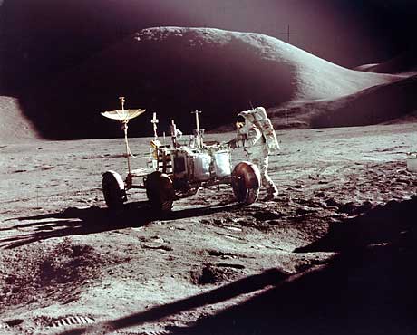 Рис.108. Вездеход на пути к горе Хэдли, освещенные гребень и вершина которой видны вдали (экспедиция на «Аполлоне-15»). Фото NASA AS15-86-11603.